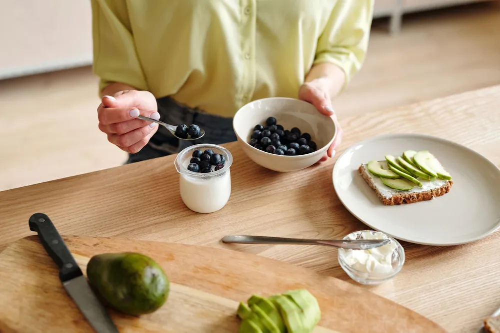 Healthy breakfast with yogurt, berries and avocado, representing digestive health