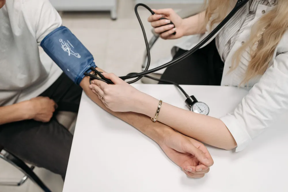 Doctor checking a patient's blood pressure, representing heart and blood pressure care