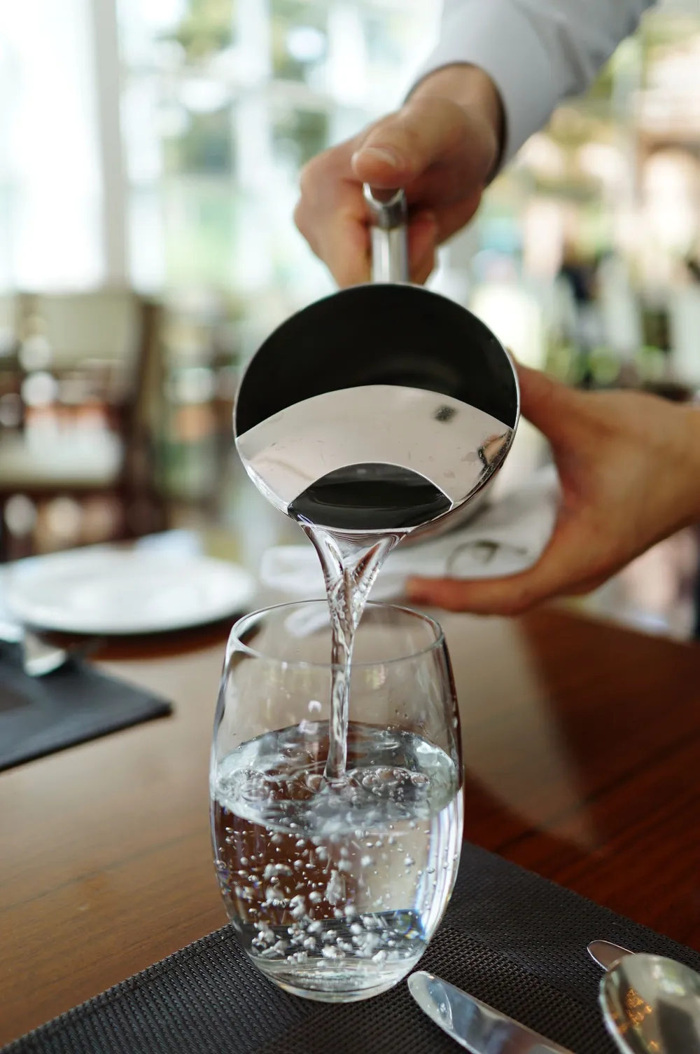 Water being poured into a glass, representing kidney and urinary health